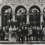 a black and white photo of employees standing in front of one of the original Levi Strauss & Co. buildings.