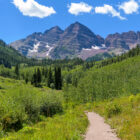 A scenic photo of Aspen featuring a grassy path and a mountain in the background