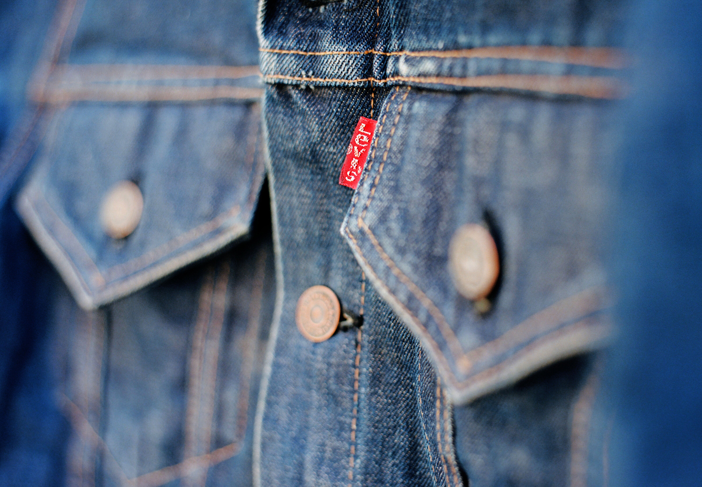 No.1 CITI A close up of the front pockets of a Levi's® denim jacket featuring a red Levi's® tab