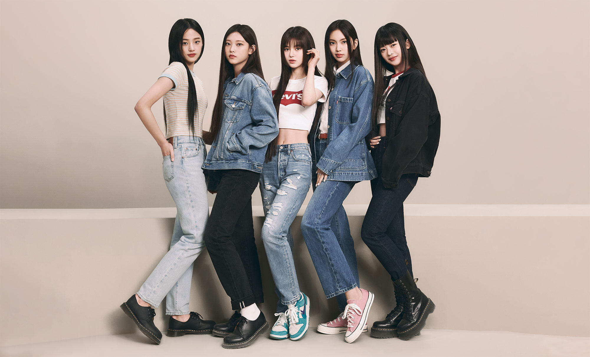 K-pop girl group NewJeans stands in front of a plain background wearing Levi's® products