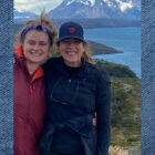 Beyond Yoga® CEO Nancy Green and her daughter stand in front of a mountain lake.