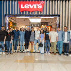 A group of 20 LS&Co. employees stand side by side and smile in front of a Levi's® store to celebrate the buy-back of Levi's® stores in Colombia.