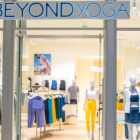 The exterior doors of Beyond Yoga® Bellevue in Seattle open to show assorted Beyond Yoga® products on mannequins and racks.