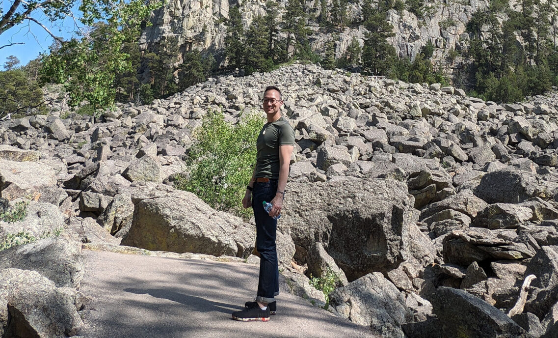 John Wang, LS&Co. vice president of Global Business Development and Licensing, stands on a hiking trail in front of a rocky mountainside.