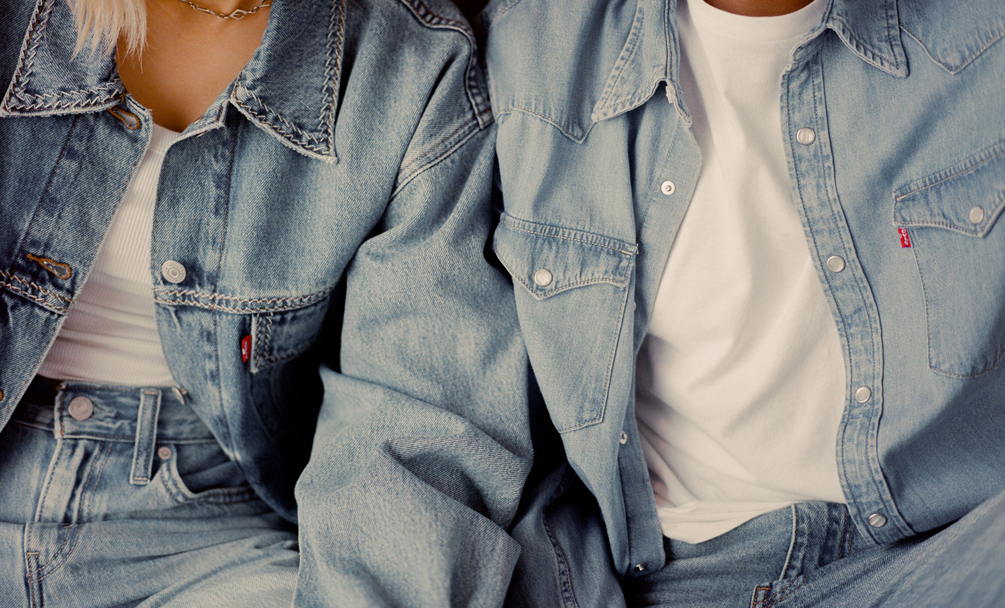 Two figures wear light wash Levi's® denim shirts over white T-shirts and light wash Levi's® denim jeans