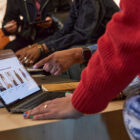 A hand points at a laptop screen showing the homepage of Levi.com