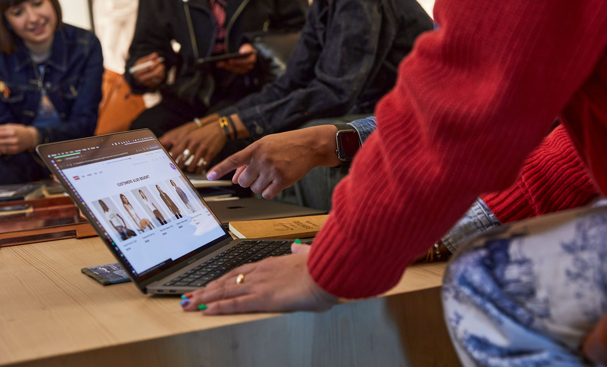 A hand points at a laptop screen showing the homepage of Levi.com