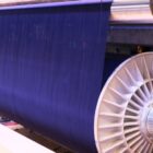 A photo of indigo colored cotton being spun on a loom