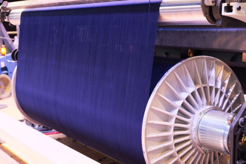 A photo of indigo colored cotton being spun on a loom
