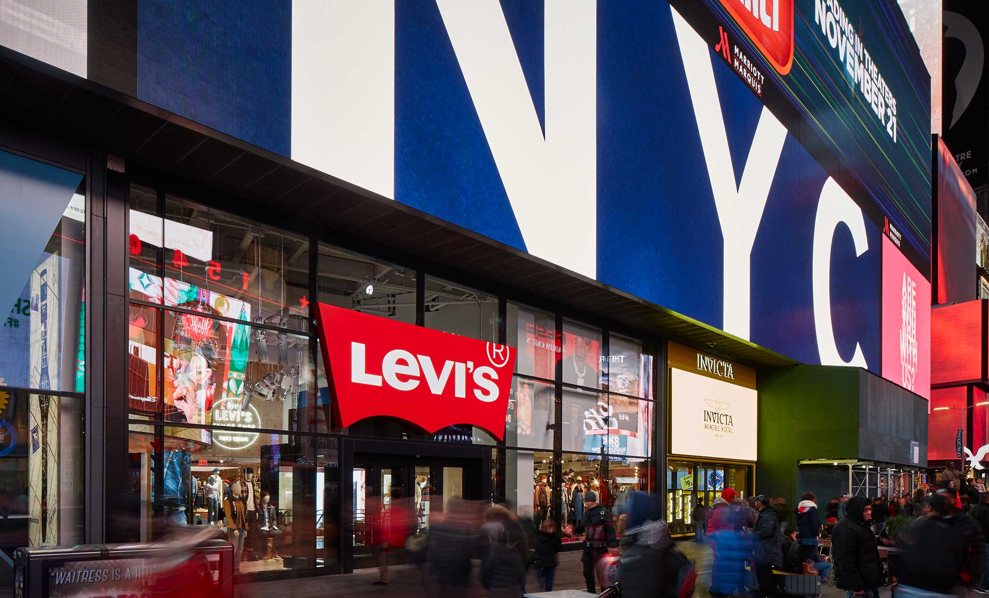 The exterior storefront of Levi's® Times Square, featuring a digital billboard above the store reading "NYC" and a red Levi's® batwing logo above the front door