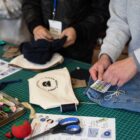 The hands of two high schoolers are seen completing sewing projects as part of the Levi's® Wear Longer Project workshop at the Levi Strauss & Co. Eureka Innovation Lab